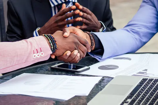 IT Consulting People Shaking Hands Over A Desk